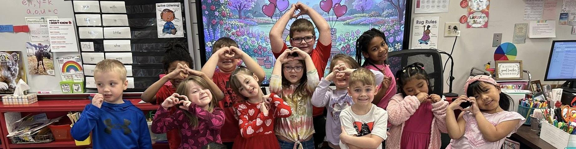 Students making heart symbols with their hands.