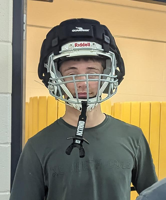 A student wears his Guardian Cap over his regular helmet.