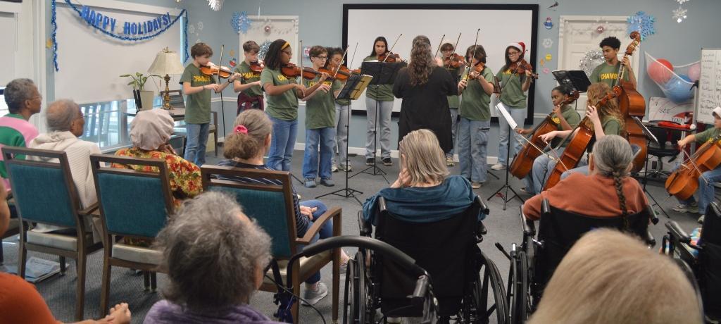 string ensemble playing for group of elderly attendees