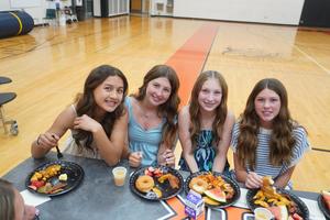Four girls sit at a table during the Breakfast of Champions celebration.
