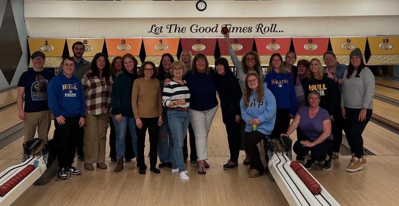 Group of friends posing for a photo at a bowling alley.