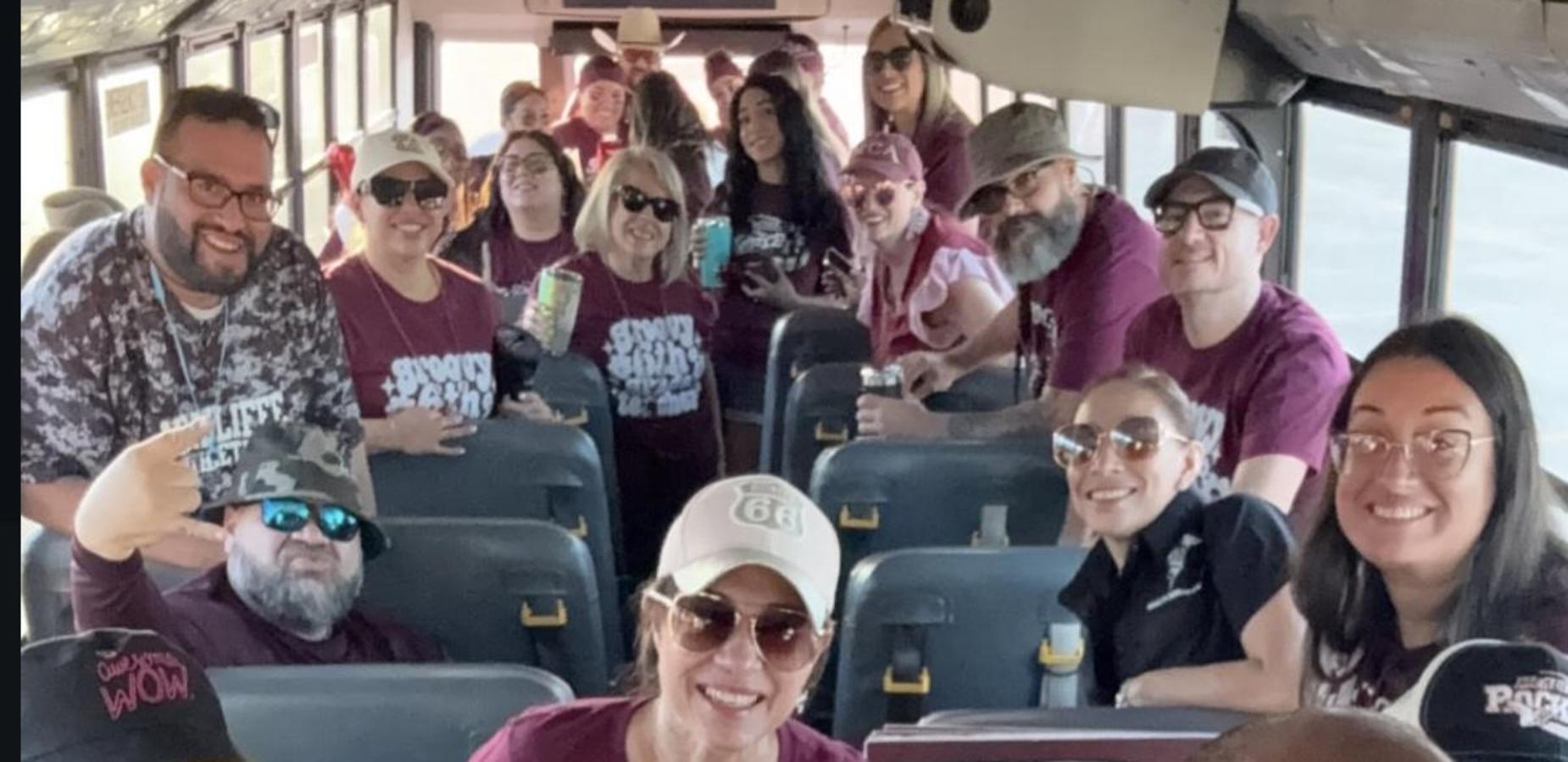 Group of people on a bus cheerfully posing with the text 'Rockets!'