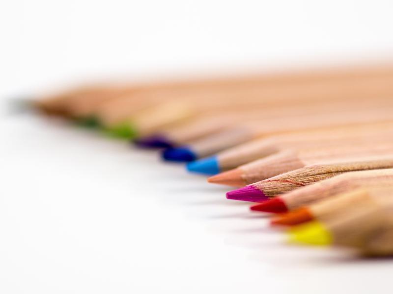 Colorful pencils lined up in a gradient on a white background.