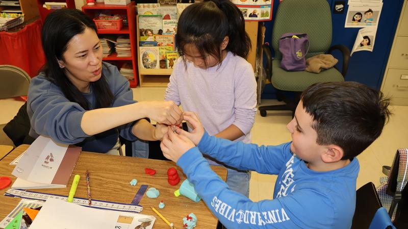 Students and a parent working on project together