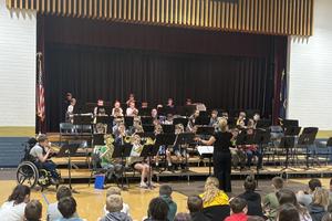 band performs on stage in front of school