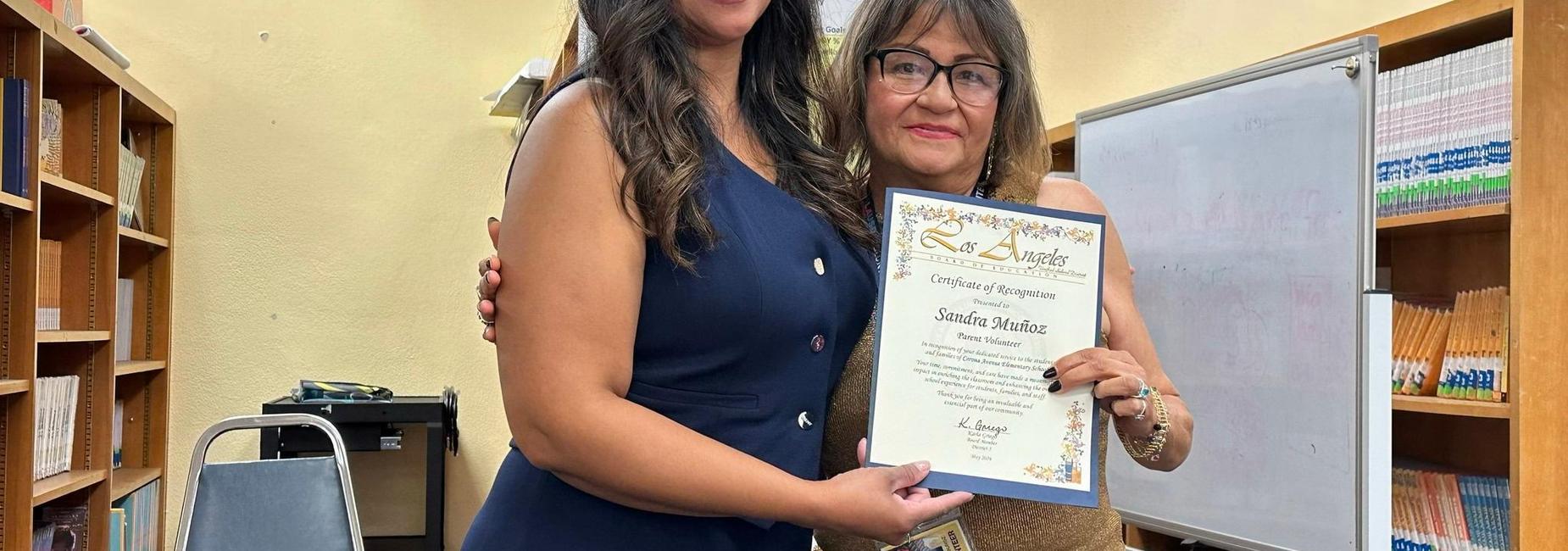 Principal handing certificate of appreciation to a parent volunteer