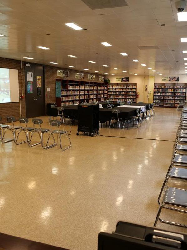 Empty library space with tables and chairs arranged for an event.