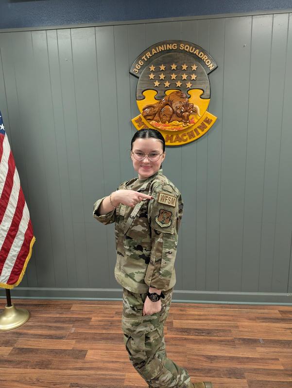 Meghan Brogan points to her uniform's shoulder patch.