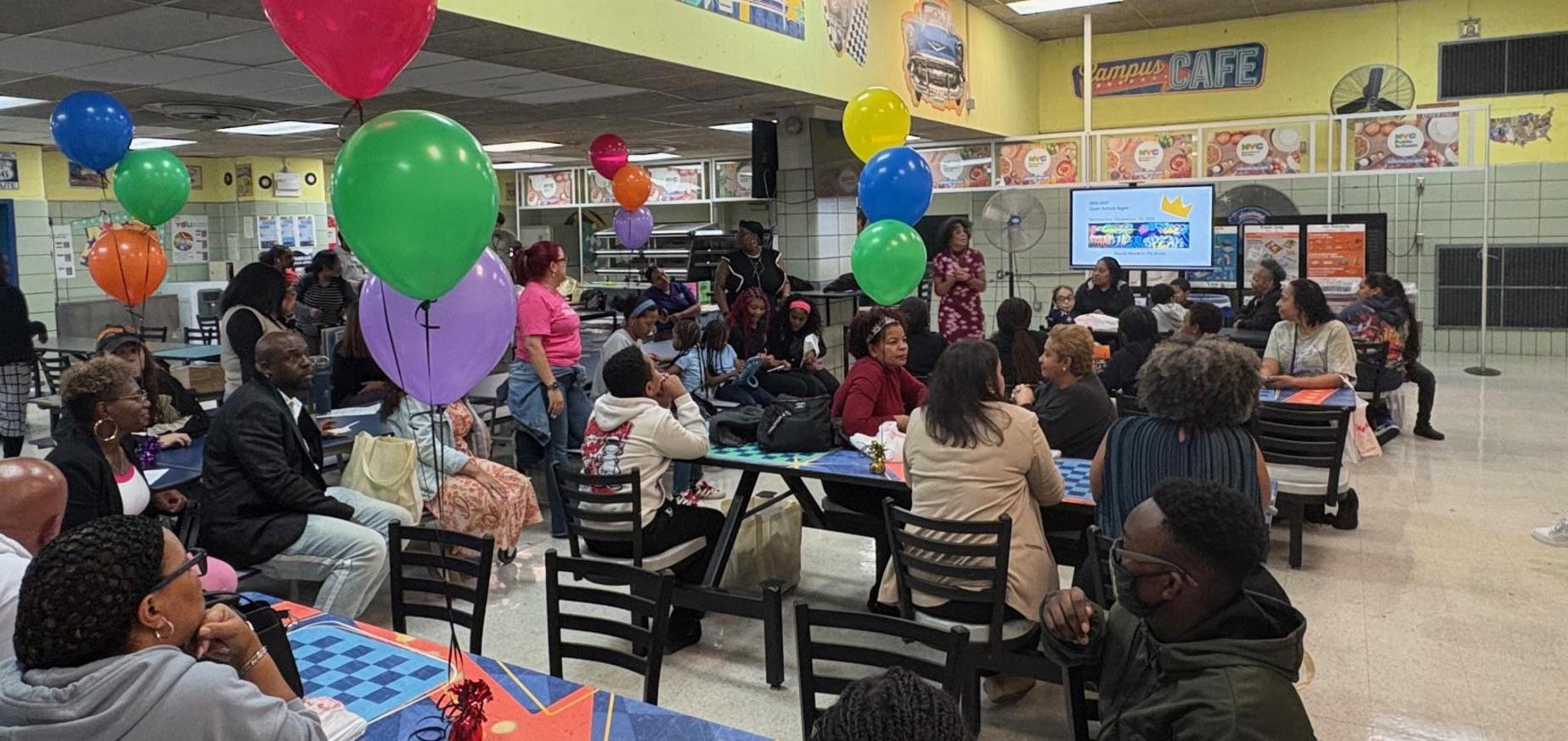 group of people sitting at tables in the school cafeteria
