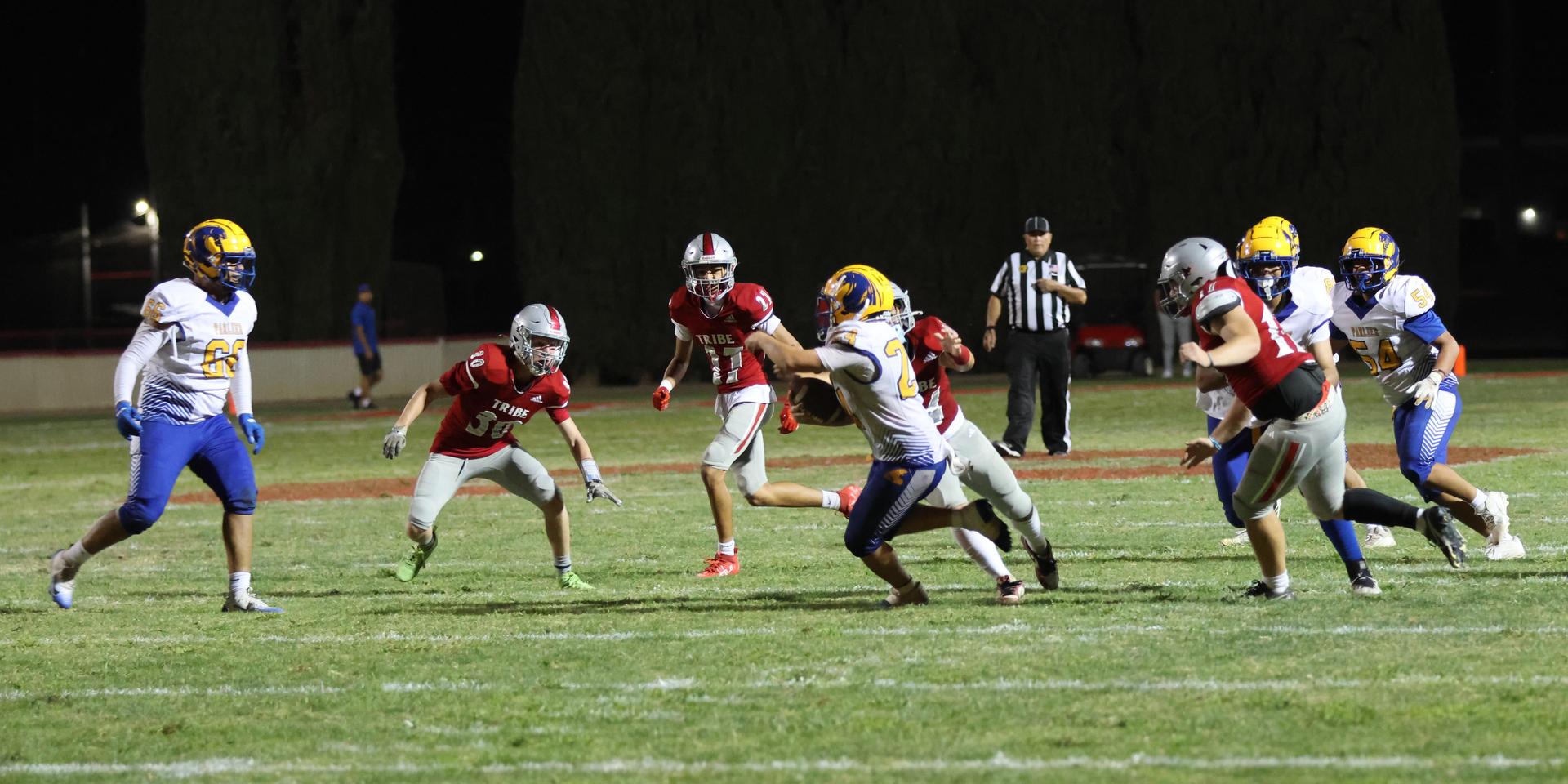 Varsity football players in action against Parlier 99
