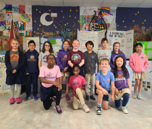 Science fair winners posing together in a group in the cafeteria