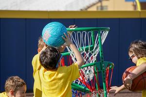 student shoots basketball in hoop