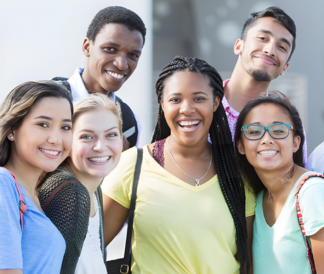 Six young people in colorful shirts and backpacks smiling at the camera