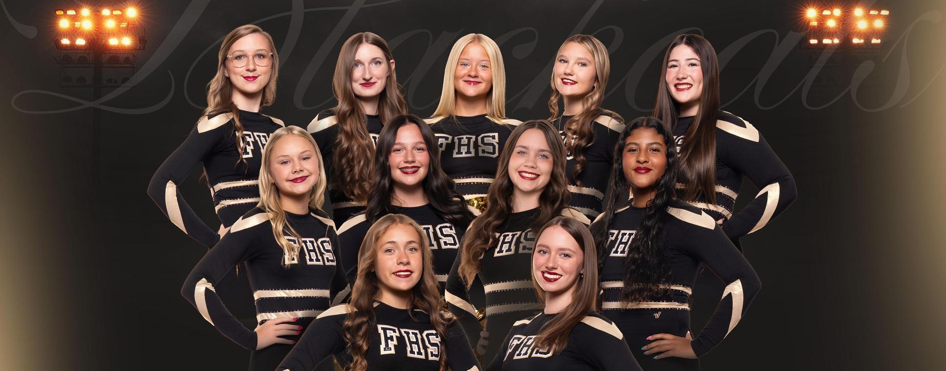 Cheerleading squad posed together in matching black and gold uniforms.