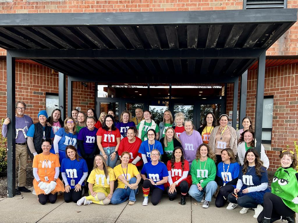 Teachers dressed in costume in front of the school.