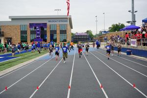 Participants sprint on a track in the 100 meter dash