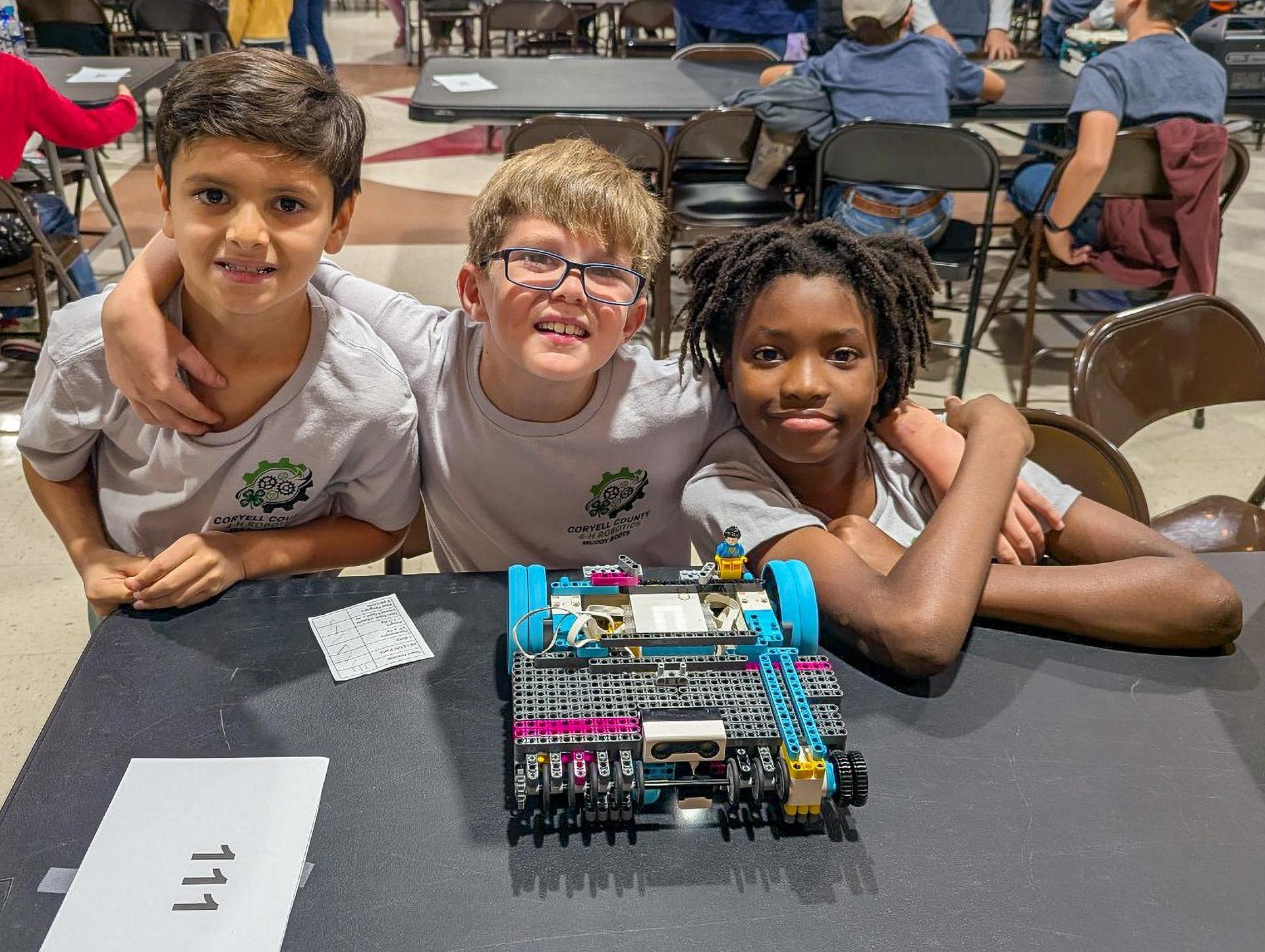 students posing with their robotics project