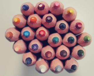 Top view of a cluster of colorful crayons arranged in a circle.