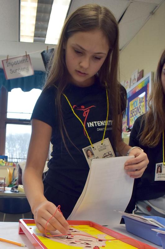 A girl working on a project with a surgical model in a classroom.
