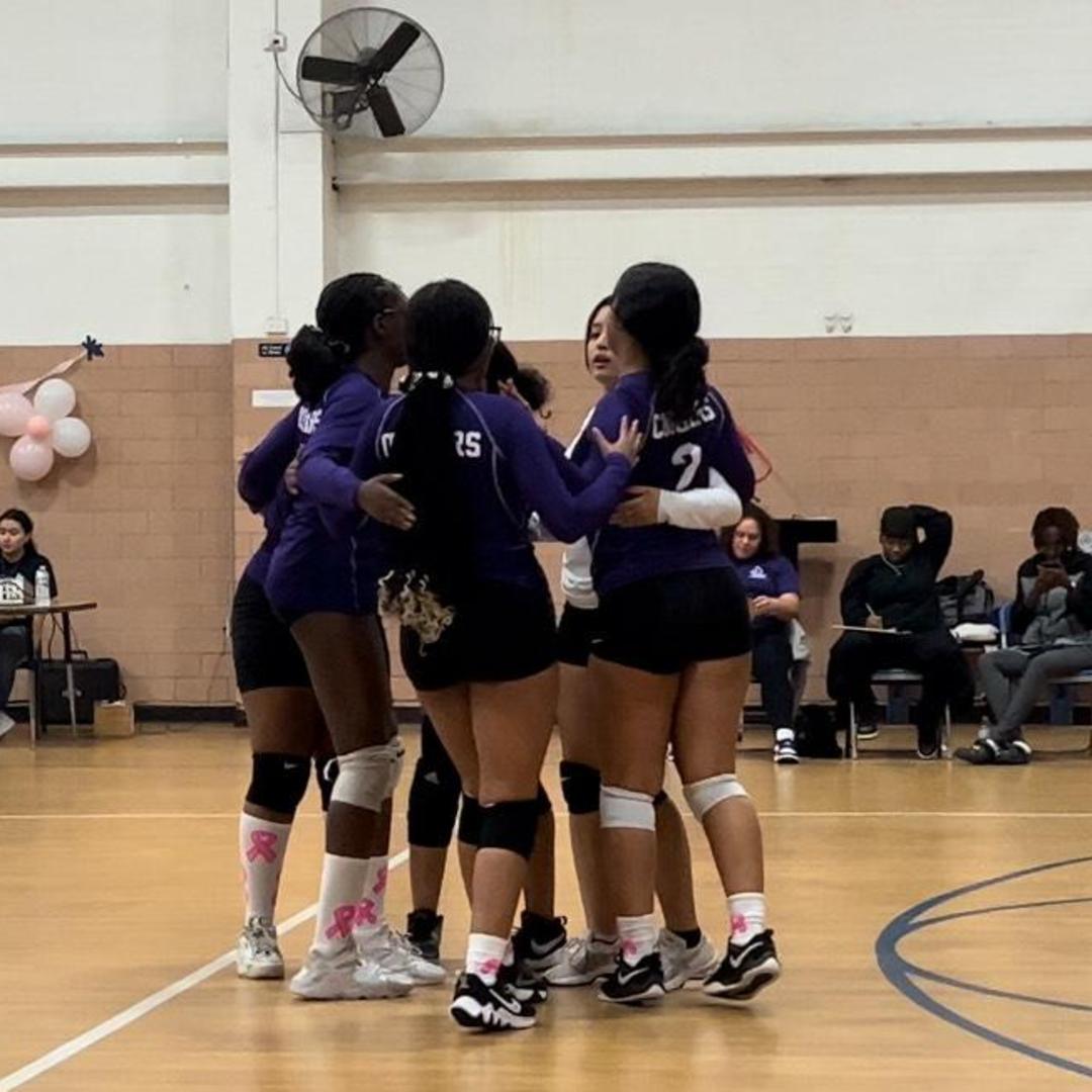 Volleyball team celebrating together in a huddle