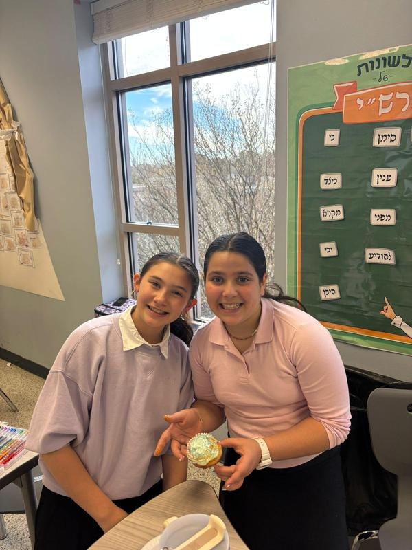 two middle school girls pose with their sufganiot