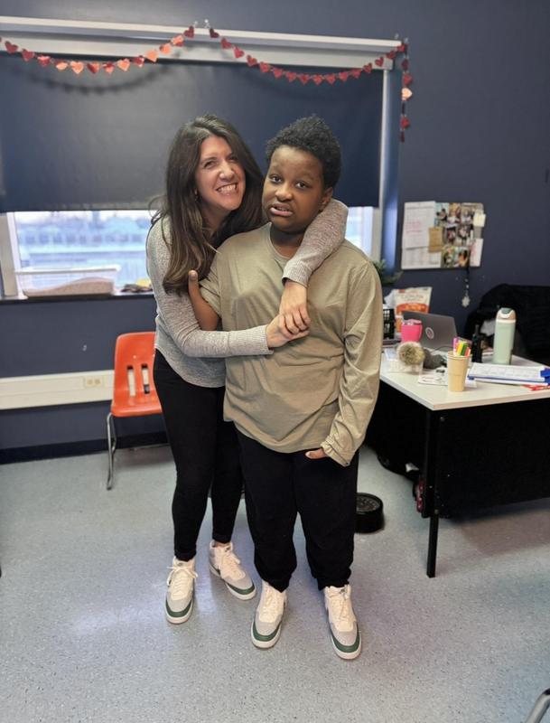 adult woman hugs middle school age boy as they both smile