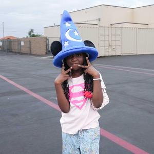 young girl wearing a blue costume hat with moon and stars