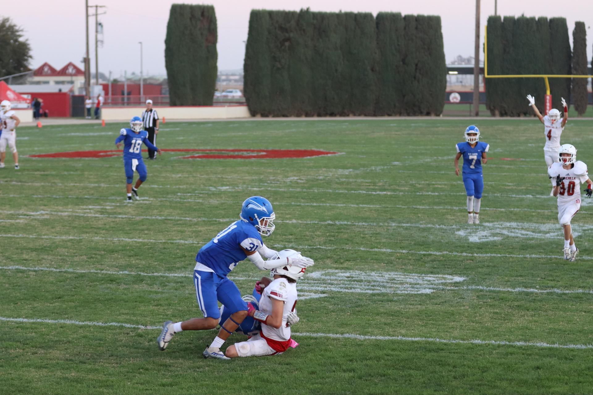 Junior Varsity football players in action against Caruthers