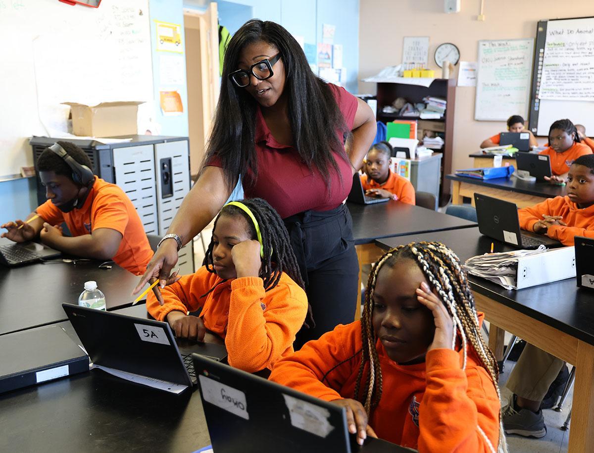 HSA Cincinnati Teacher and student interacting at a classroom desk
