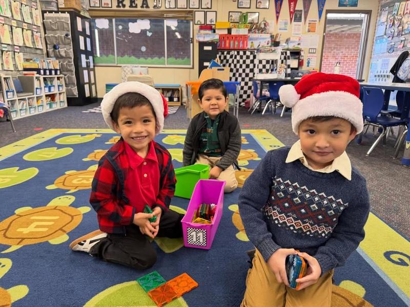 about three students in class with santa hats