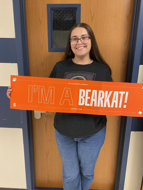 Student holding up a bearcat sign.