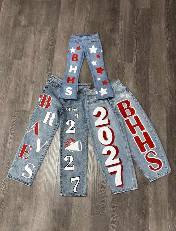 Four pairs of decorated jeans displaying team colors and symbols for BHHS and 2027.