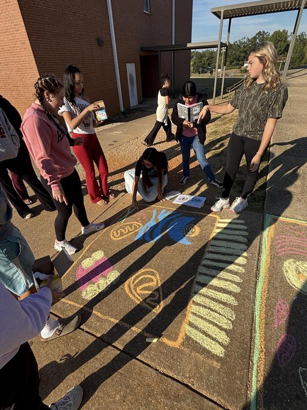 Group of students working on sidewalk art of the cell