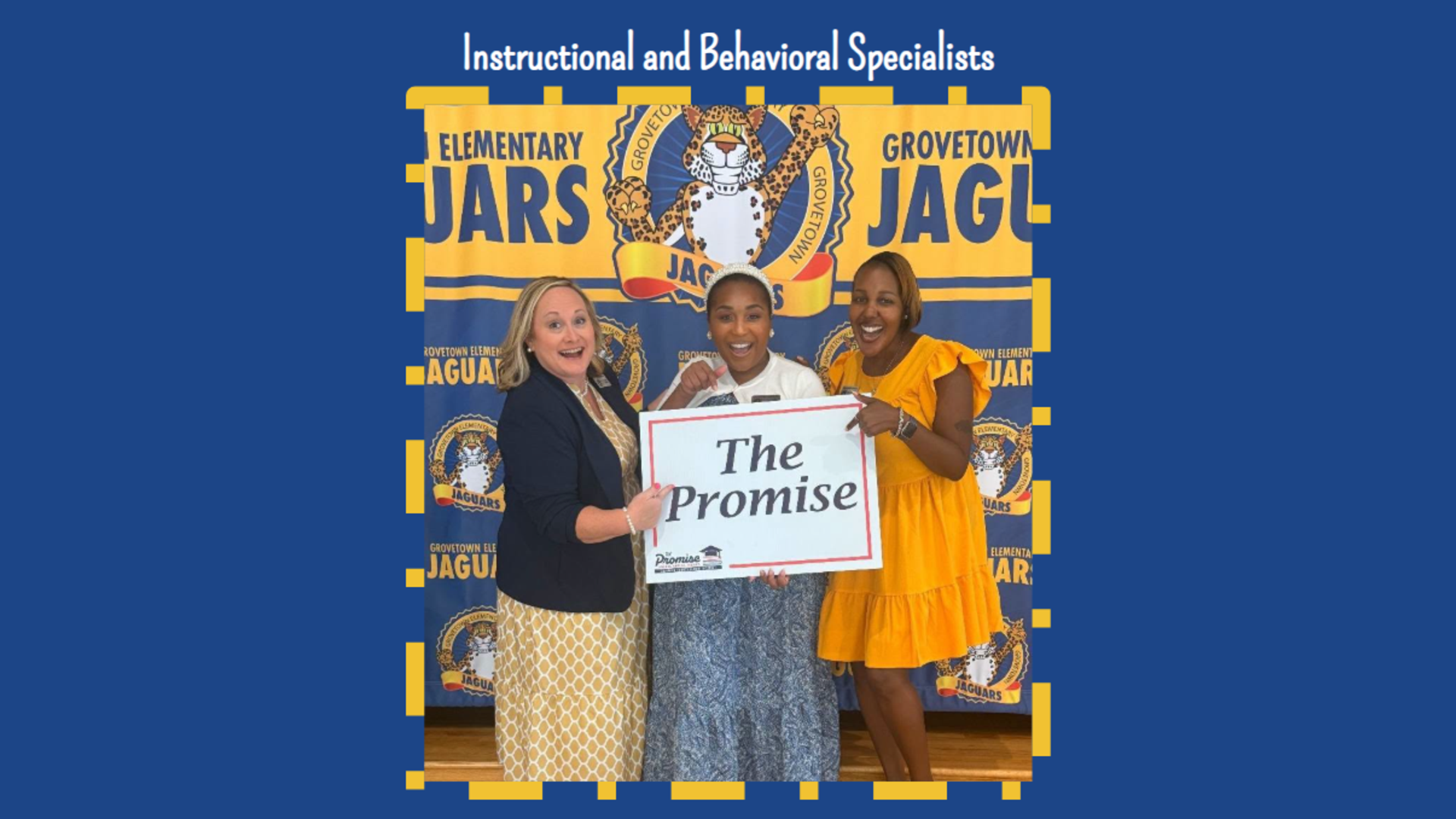 Three specialists hold a sign reading 'The Promise' in front of a school banner.