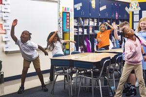 Elementary students dance around