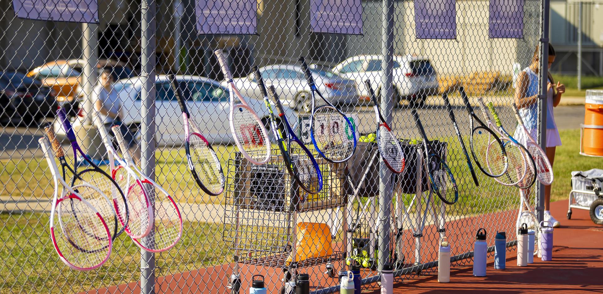 Tennis rackets hung on the fence
