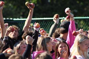 Students hold apples in the air