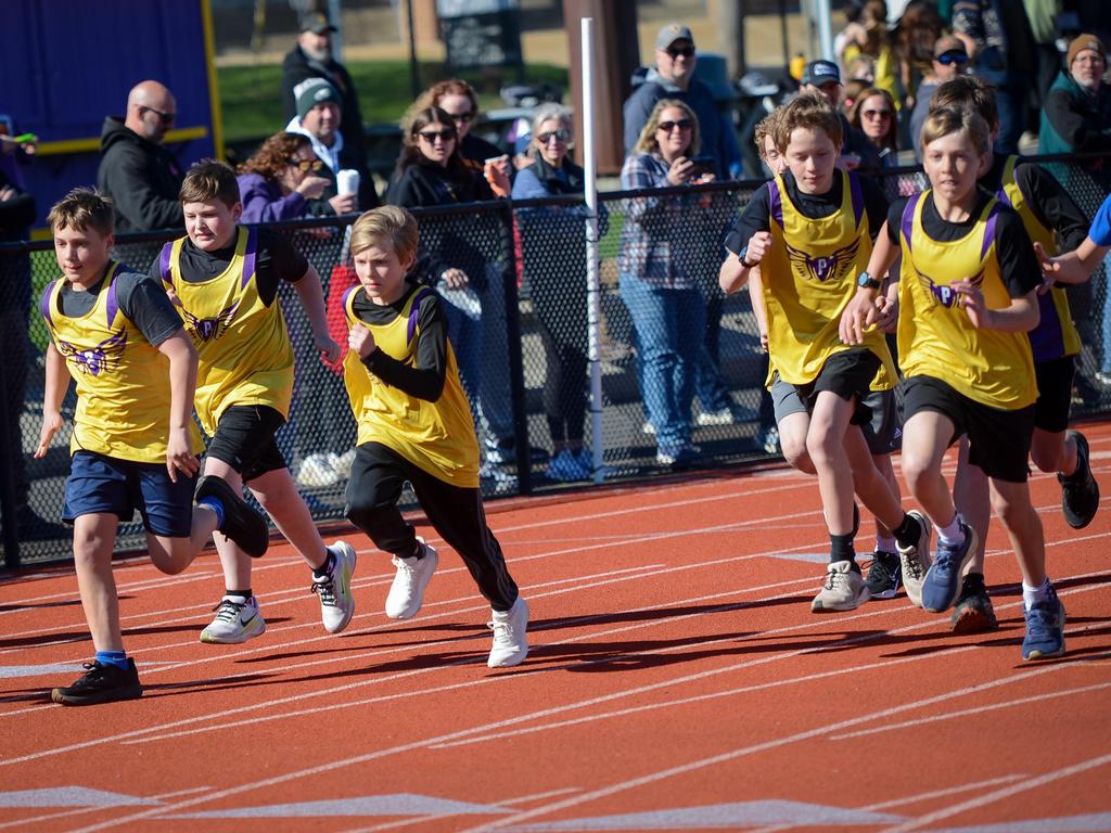Track & field athletes in a race on the track.