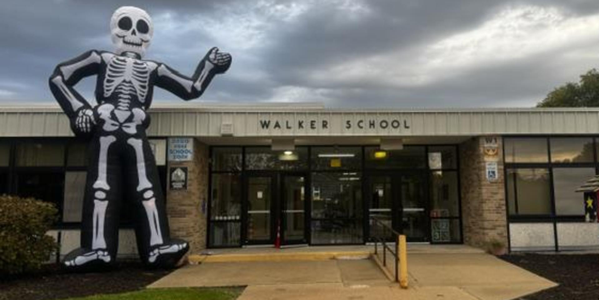 Large inflatable skeleton welcoming visitors at Walker School entrance.