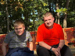 two students sitting on a bench smiling for camera