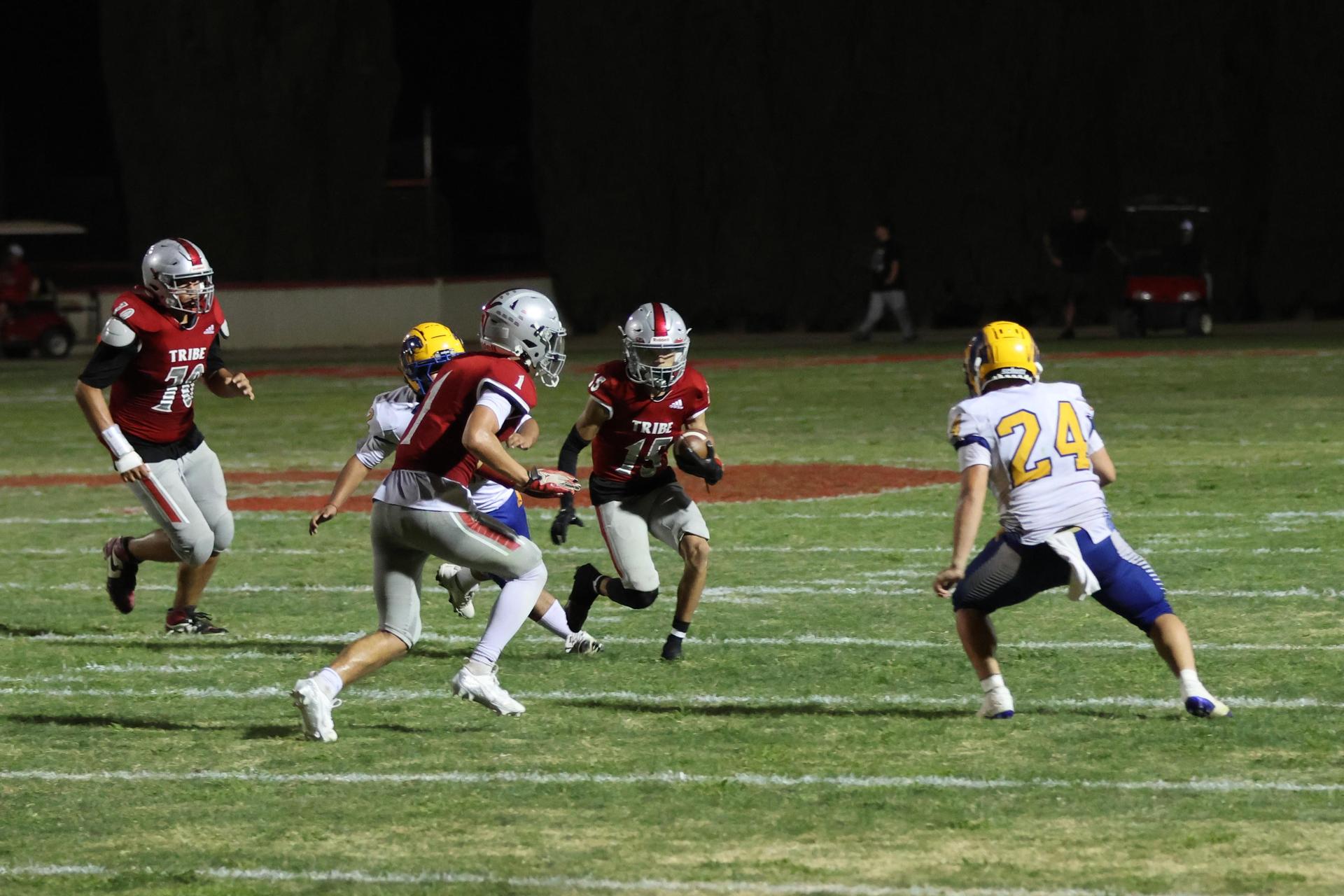 Varsity football players in action against Parlier 14