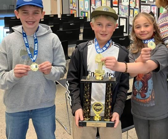 three students with trophy
