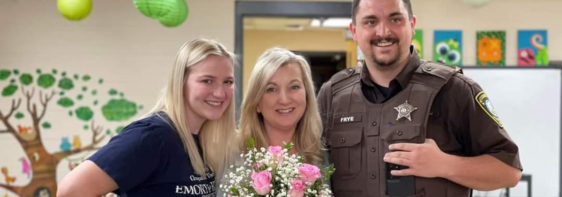 Mrs. Diane Frye, Teacher of the Year at CES, pictured with two of her three children, holding vase of flowers given by the school in honor of this achievement.