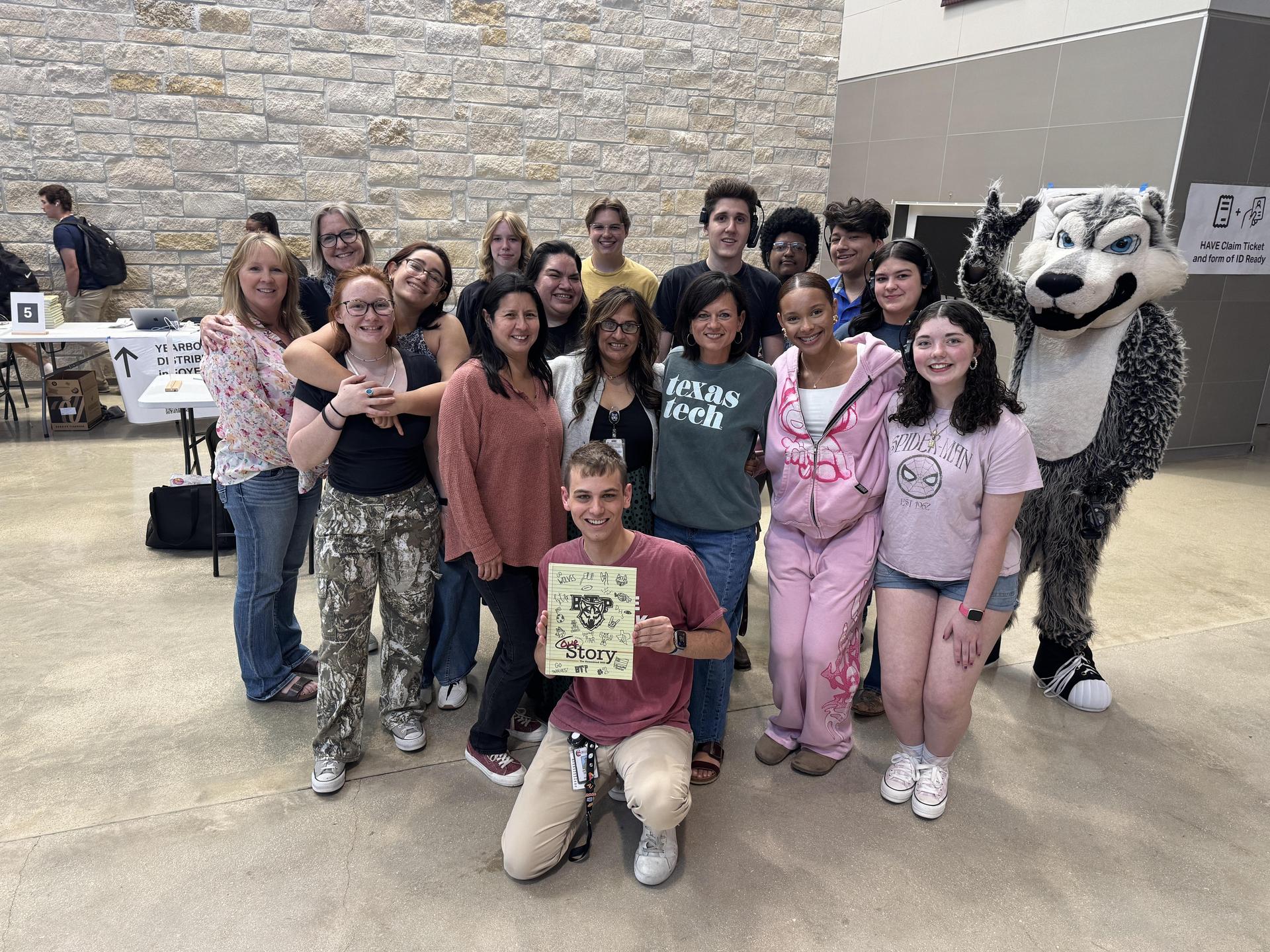 Students and Mr. DeLane holding a yearbook