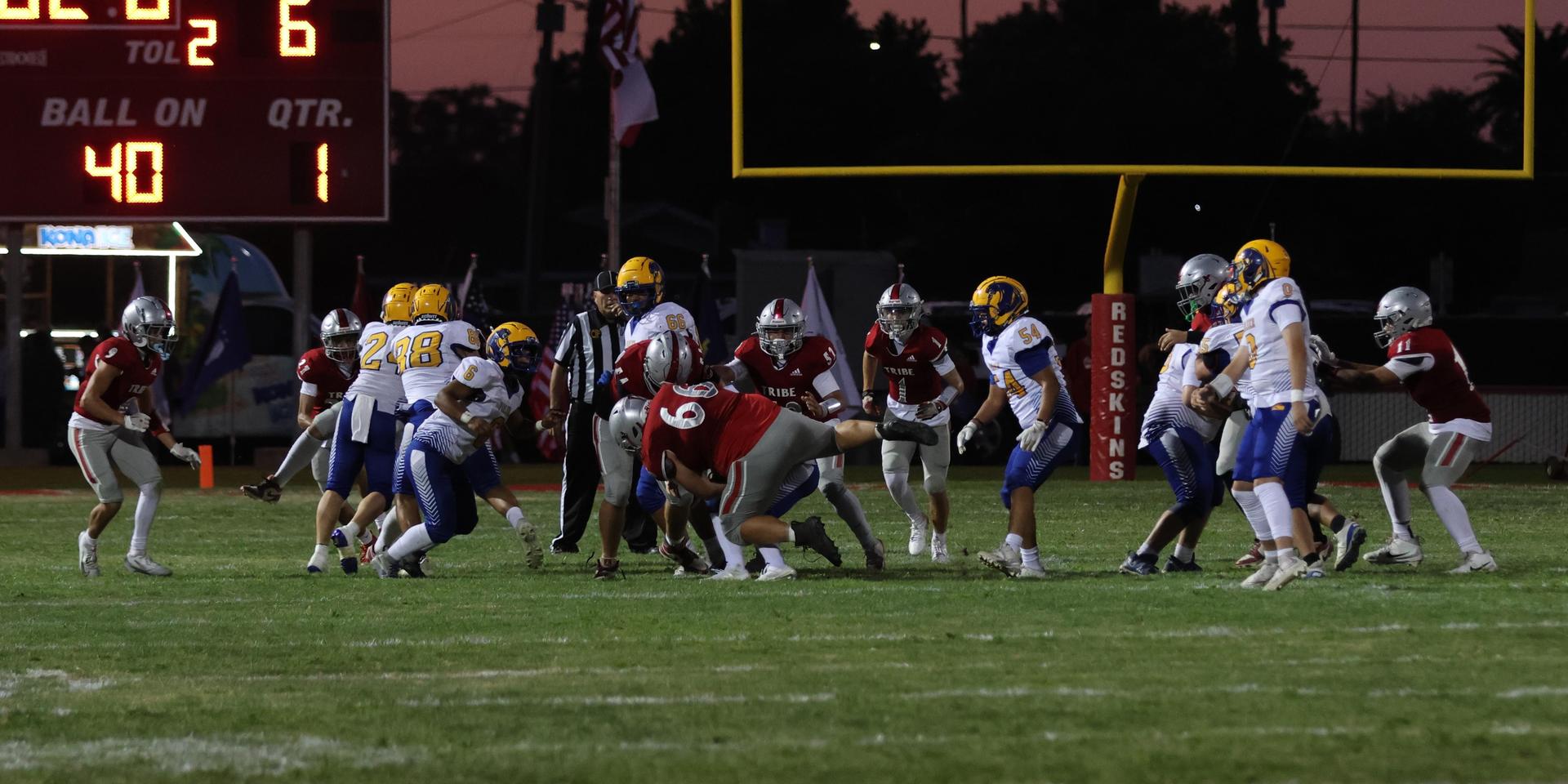 Varsity football players in action against Parlier 10