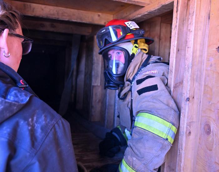 fire science student climbing out of tight spot