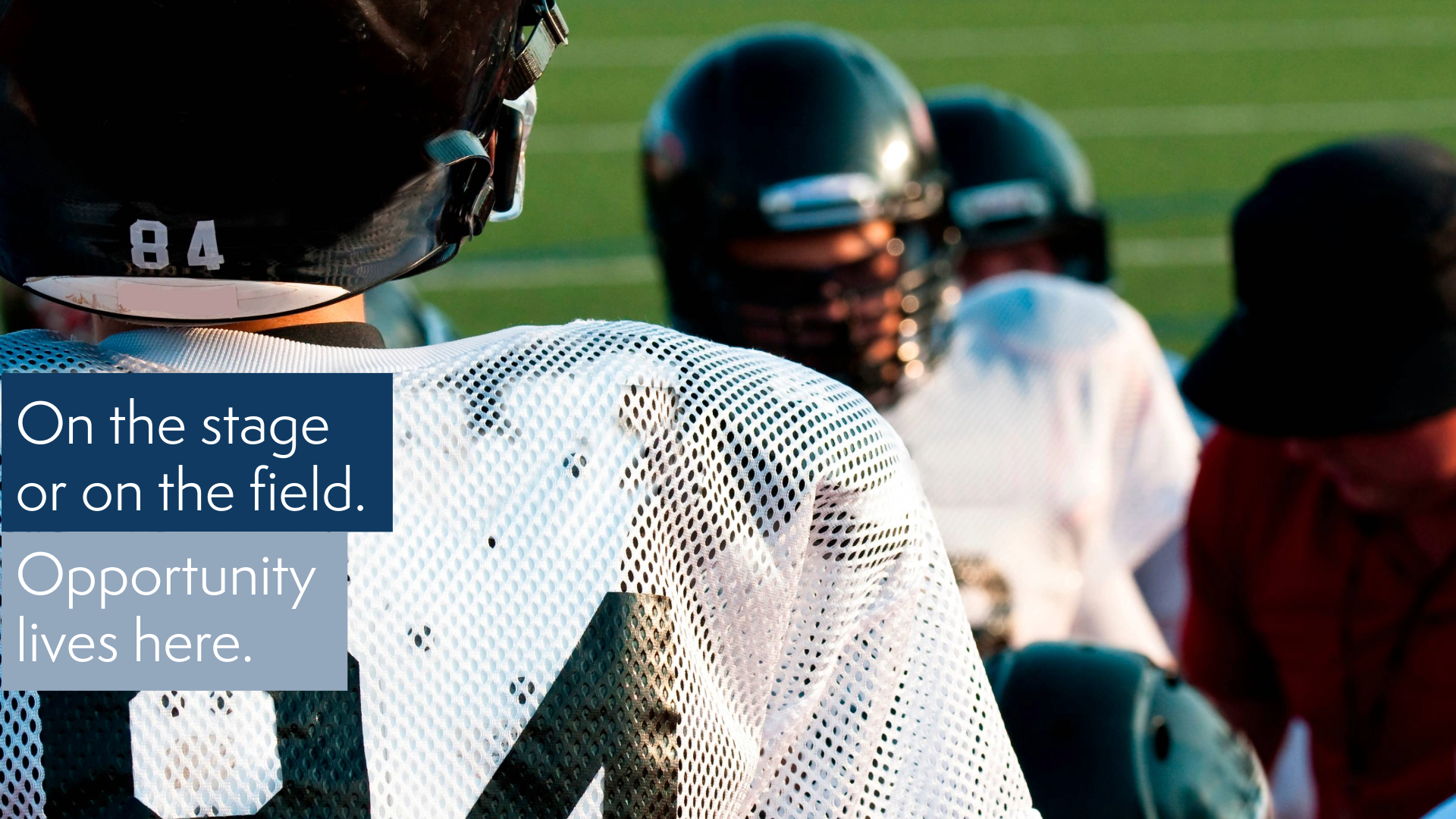 close up of the back of a High School football player in helmet and uniform with teammates and coach in soft focus with text that reads On the stage or on the field. Opportunity lives here.