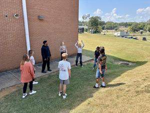 A group of students stand at the bottom of the hill