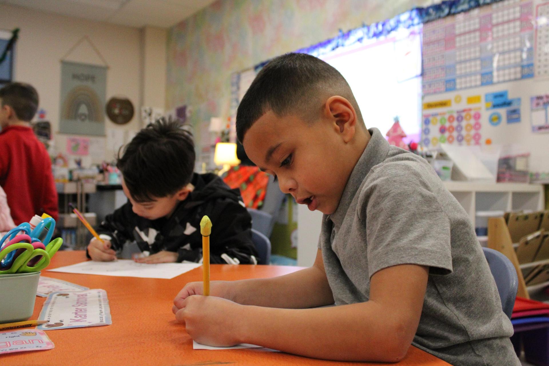 Elementary Students writes on paper