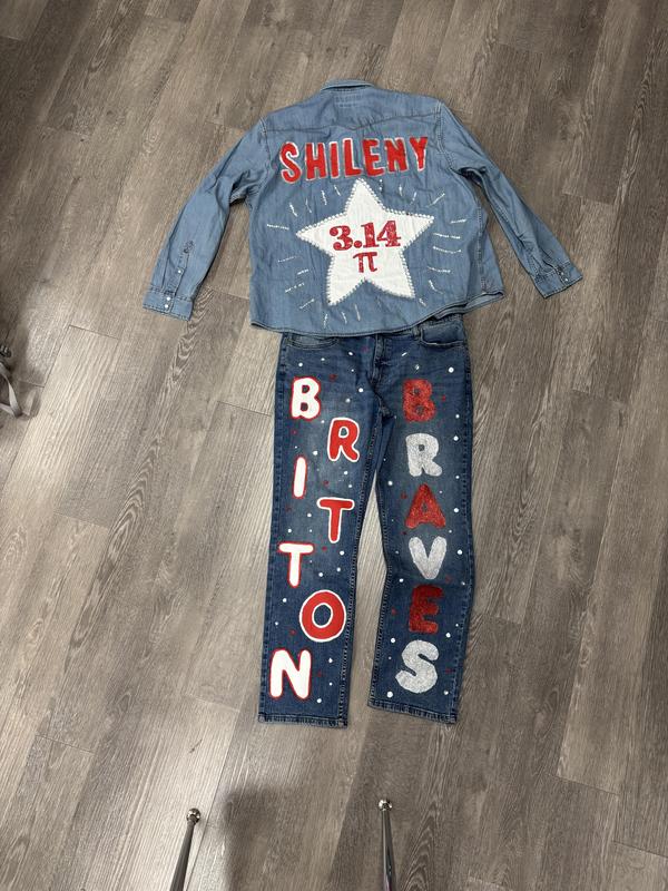A denim jacket and jeans with custom designs, including a star and sports-related text.